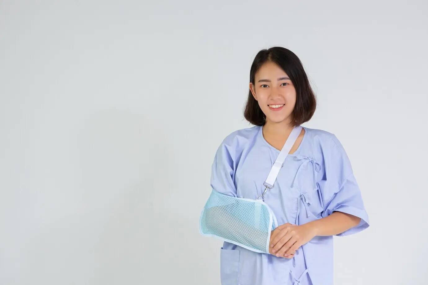 Молодая женщина с переломом руки, на руке надета шина.