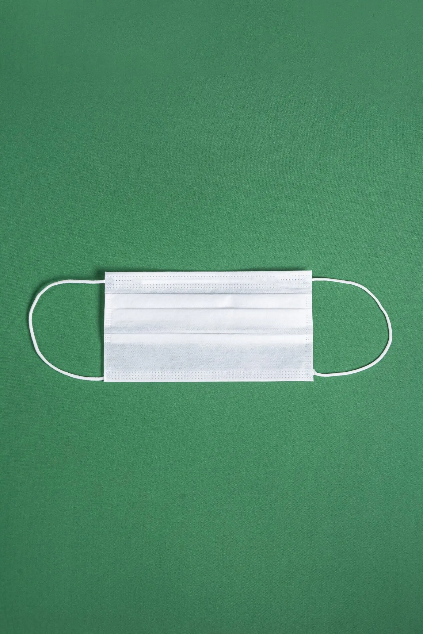 Хирургическая маска на минималистичном зелёном фоне