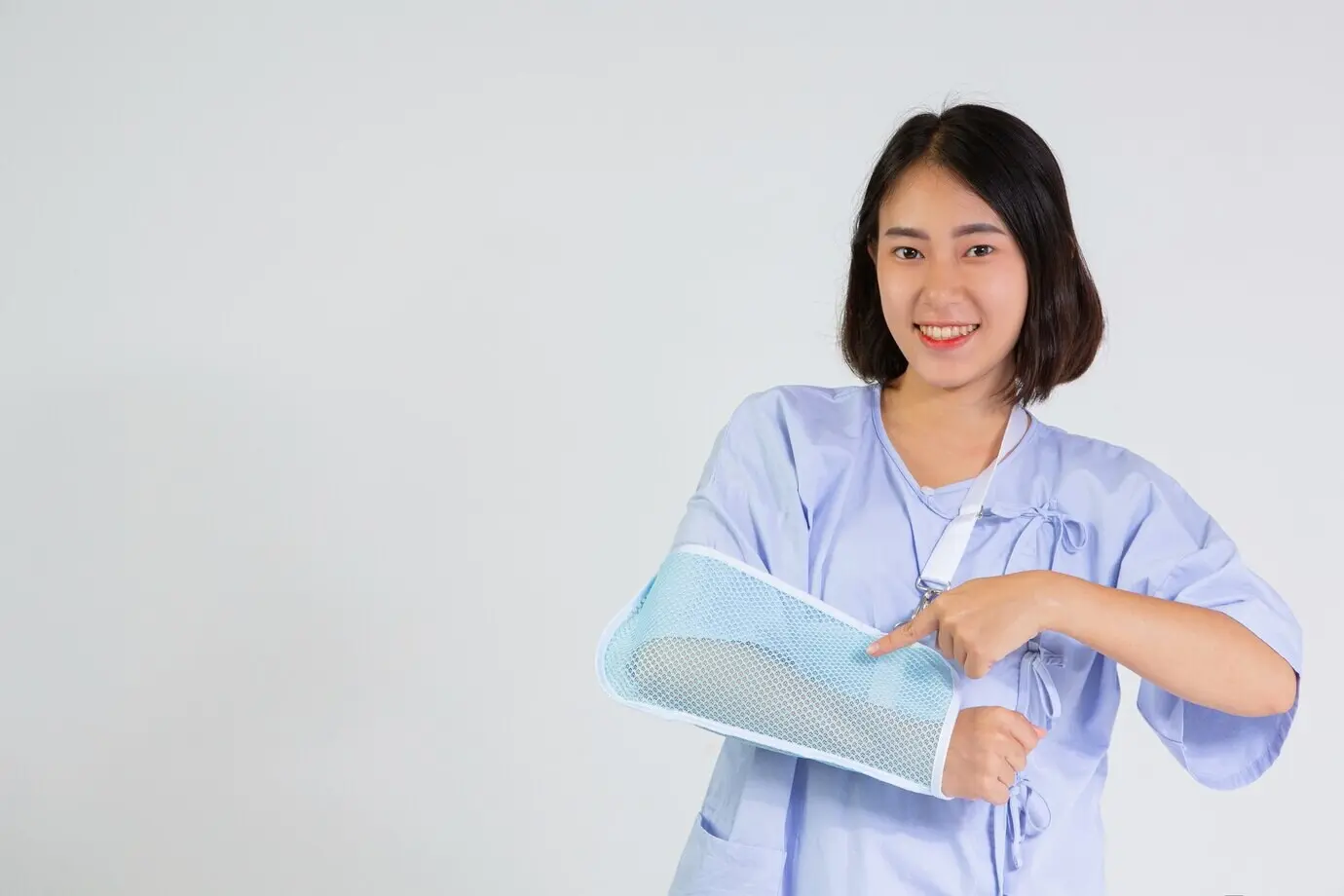 Молодая женщина с переломанной рукой, на которой надета шина.